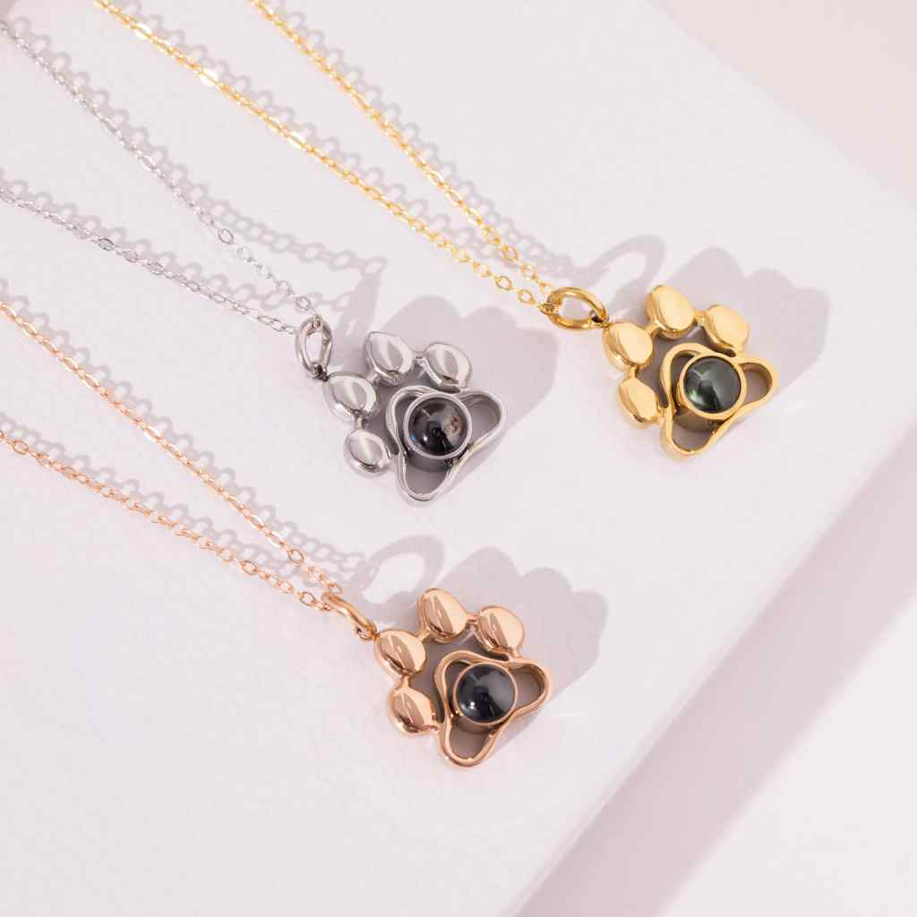 Silver paw print photo necklace with a pet photo hidden inside the pendant