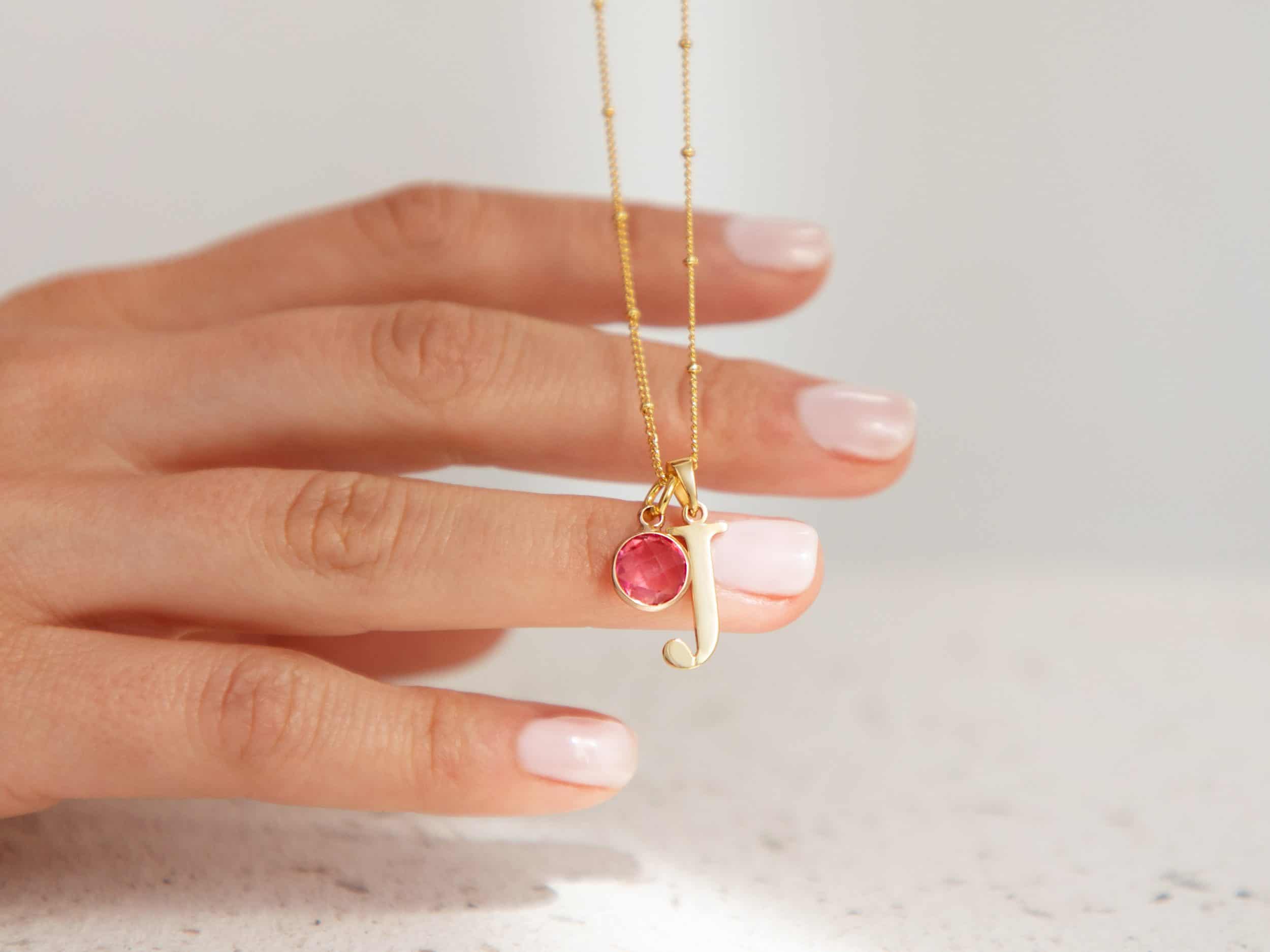close up of initial and birthstone necklace