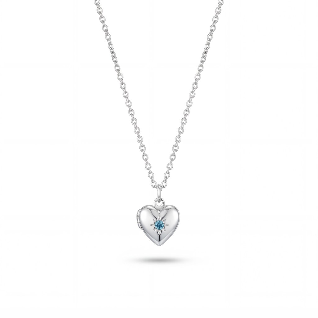 Silver heart pendant necklace with a blue gemstone, hanging from a chain against a white background.