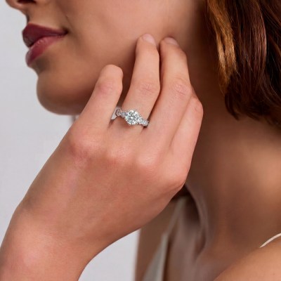 Close-up of a woman's neck and jaw as she touches her skin; wearing a large diamond ring on her finger.